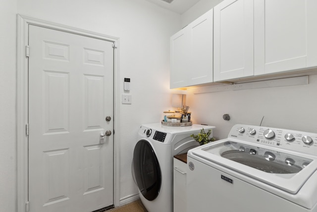 washroom featuring cabinets and separate washer and dryer