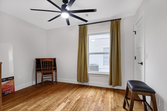 living area featuring hardwood / wood-style flooring and ceiling fan