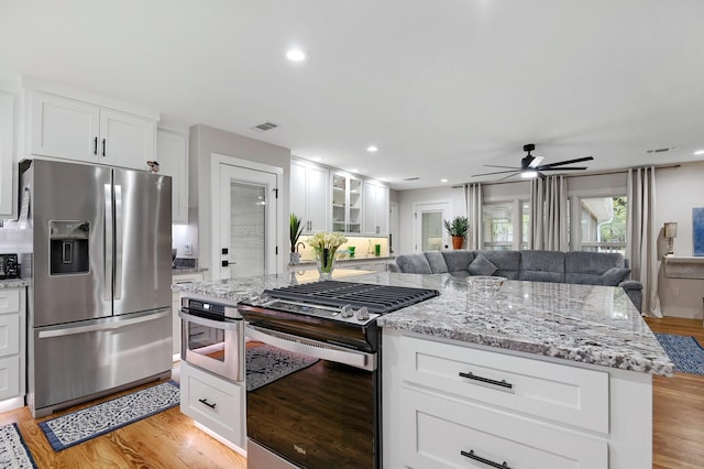 kitchen with white cabinetry, appliances with stainless steel finishes, and light wood-type flooring