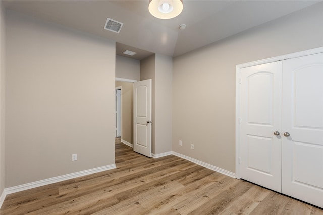 unfurnished bedroom with light hardwood / wood-style floors and a closet