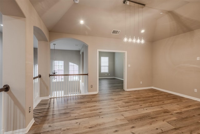 unfurnished room featuring hardwood / wood-style flooring and high vaulted ceiling