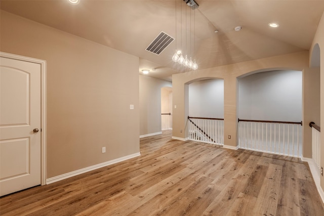 empty room featuring lofted ceiling and light hardwood / wood-style flooring