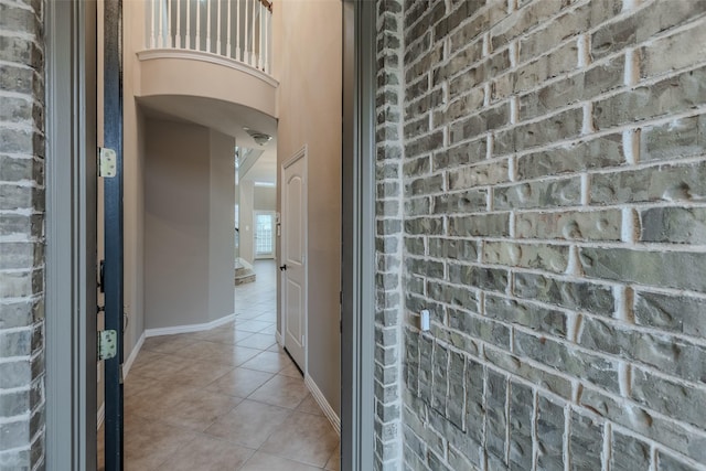 interior space with brick wall and light tile patterned floors