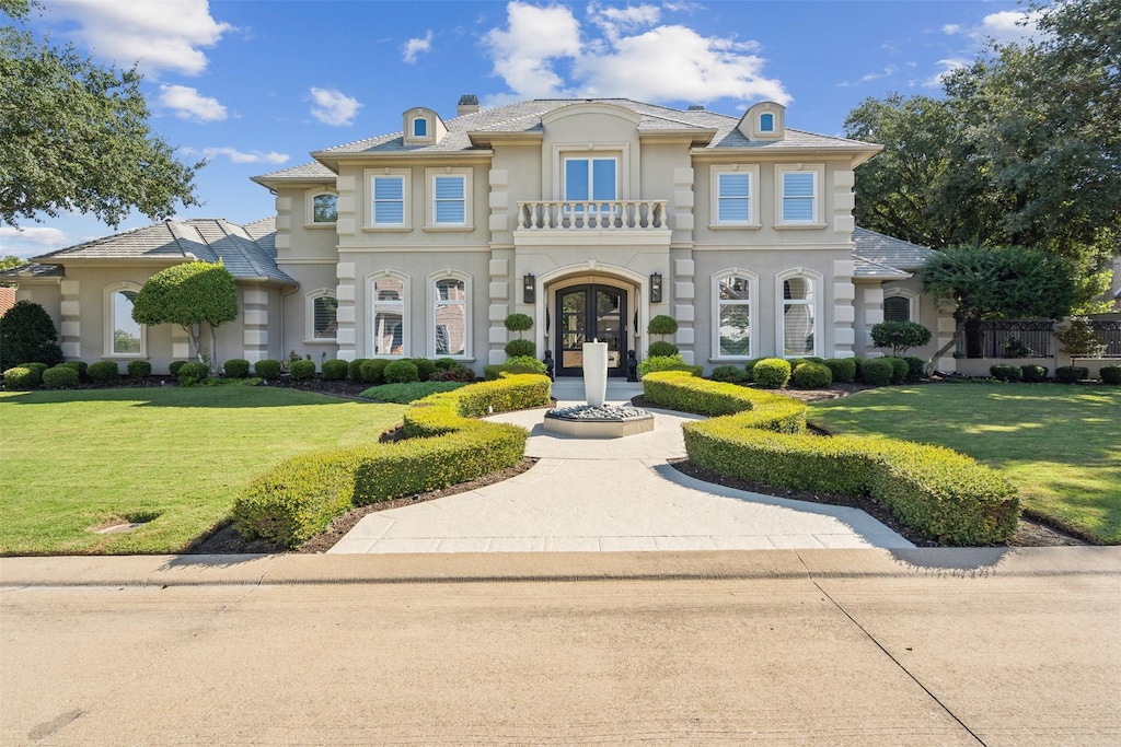 mediterranean / spanish-style home featuring a front yard and french doors