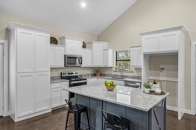 kitchen with stainless steel appliances, a center island, and white cabinets