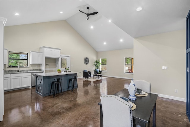 dining room featuring sink and high vaulted ceiling