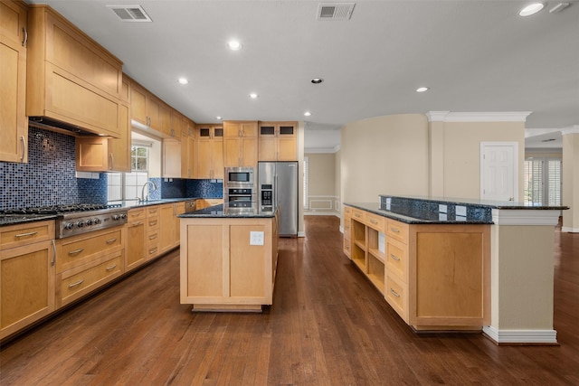 kitchen featuring backsplash, stainless steel appliances, a center island, and dark stone countertops