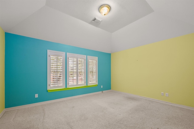 spare room with vaulted ceiling and carpet