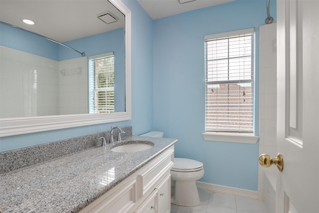 bathroom with vanity, toilet, and a tile shower