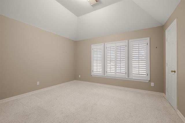 spare room with vaulted ceiling and carpet