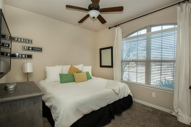 bedroom with multiple windows, ceiling fan, and carpet