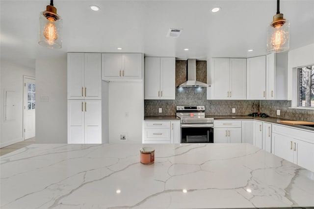 kitchen featuring white cabinetry, wall chimney exhaust hood, decorative light fixtures, and stainless steel electric range oven