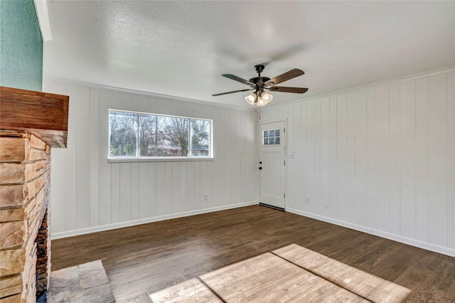 empty room featuring dark wood-type flooring, ceiling fan, and a textured ceiling