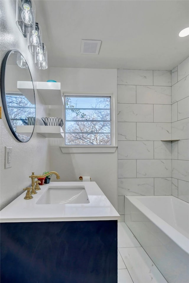 bathroom featuring vanity and tiled shower / bath