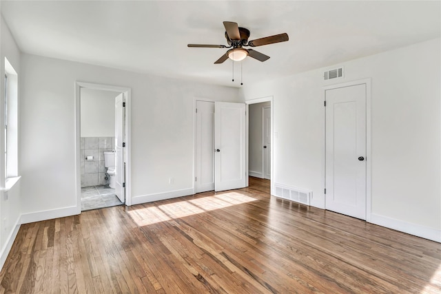 unfurnished bedroom with ceiling fan, connected bathroom, and light wood-type flooring