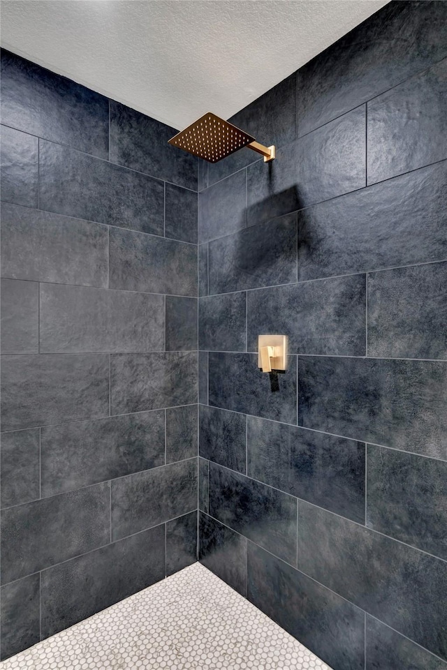 room details with tiled shower and a textured ceiling