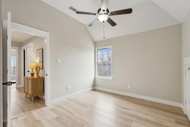 empty room with light wood finished floors, baseboards, visible vents, ceiling fan, and vaulted ceiling