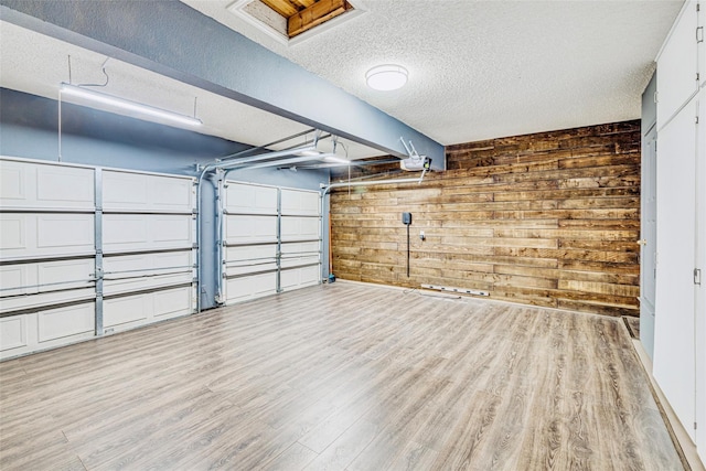 garage with a garage door opener and wood walls