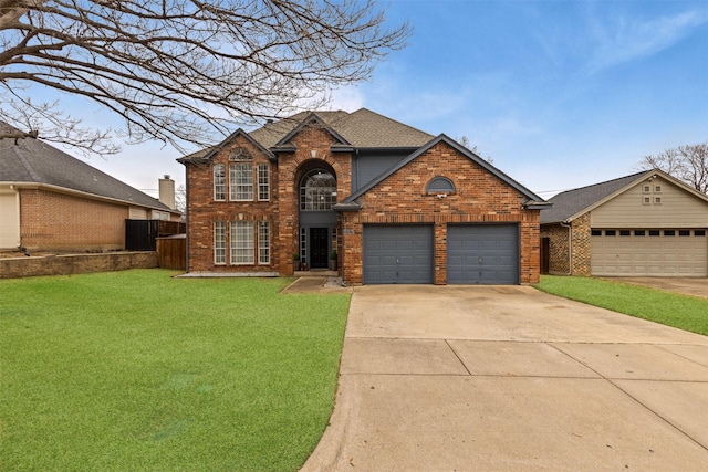 view of property featuring a garage and a front lawn