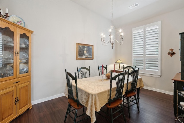 dining area featuring vaulted ceiling, dark wood-type flooring, and an inviting chandelier