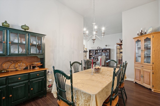 dining room featuring dark hardwood / wood-style flooring, a notable chandelier, and vaulted ceiling