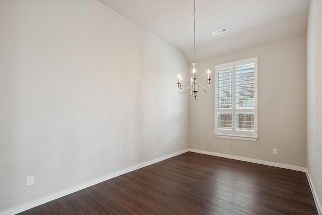 spare room with baseboards, an inviting chandelier, dark wood-style floors, and visible vents