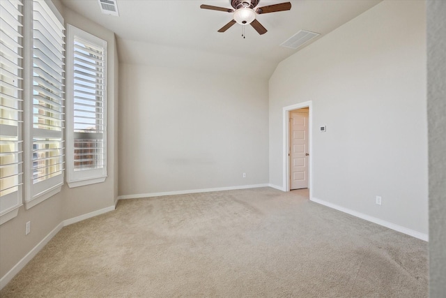 empty room featuring visible vents, a ceiling fan, carpet, and lofted ceiling