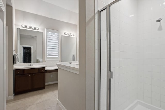 bathroom featuring two vanities, a shower stall, and a sink