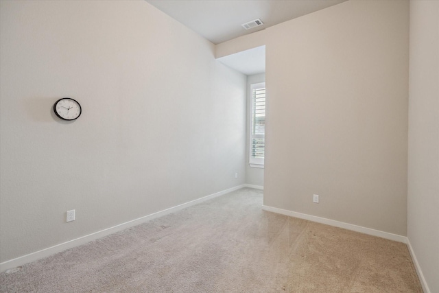 empty room with baseboards, light colored carpet, and visible vents