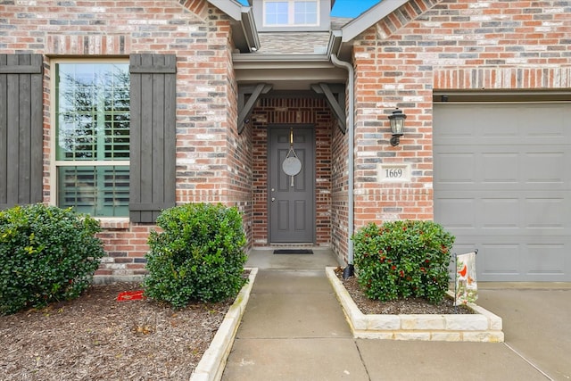 property entrance featuring a garage and brick siding