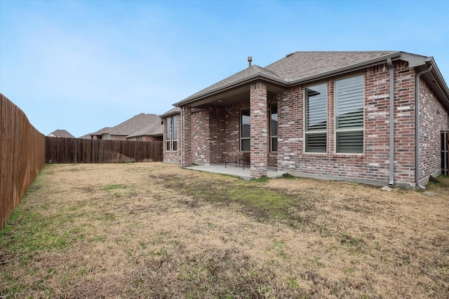 rear view of house with a yard and a patio area