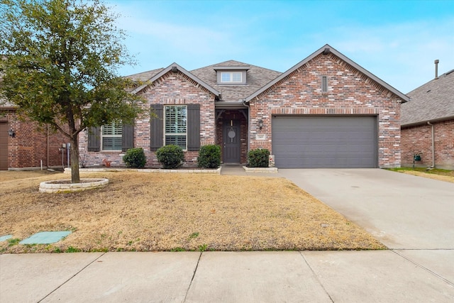 view of front of house with a garage, a front lawn, brick siding, a shingled roof, and concrete driveway