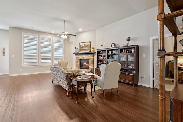 living room with dark wood-type flooring, ceiling fan, and a fireplace