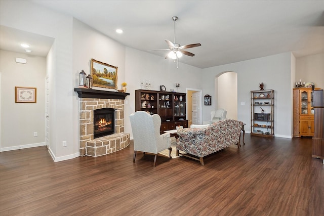 living room with ceiling fan, dark hardwood / wood-style floors, and a fireplace