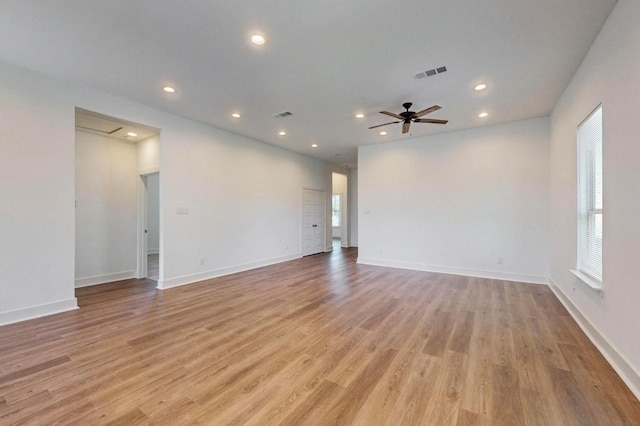 empty room with ceiling fan and light hardwood / wood-style floors