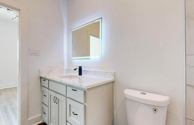 bathroom with vanity, hardwood / wood-style flooring, and toilet