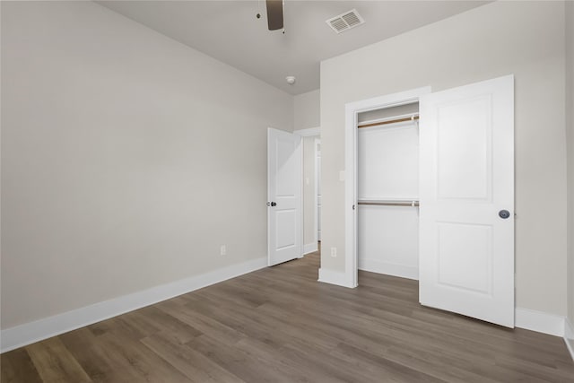 unfurnished bedroom featuring a closet, dark hardwood / wood-style floors, and ceiling fan