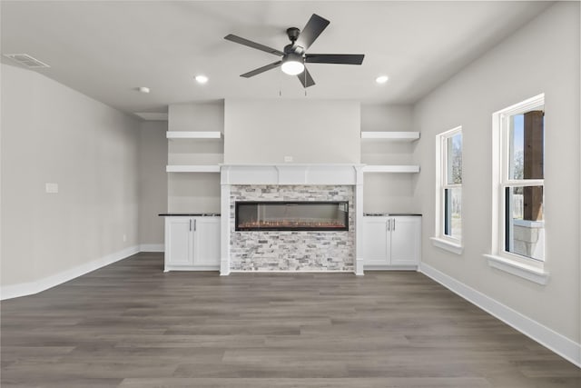 unfurnished living room with dark wood-type flooring and ceiling fan