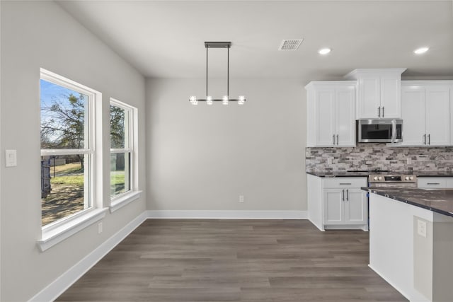 kitchen featuring pendant lighting, white cabinetry, backsplash, stainless steel appliances, and dark hardwood / wood-style floors