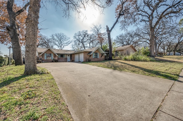 ranch-style house featuring a front yard, driveway, and an attached garage