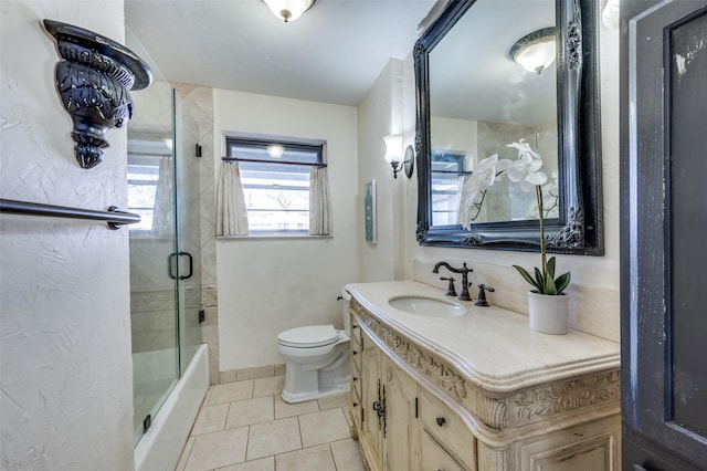 bathroom featuring toilet, vanity, baseboards, tile patterned floors, and a shower with door