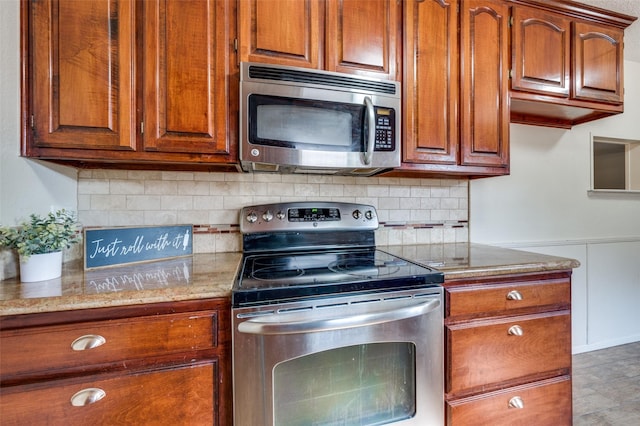 kitchen featuring light stone countertops, appliances with stainless steel finishes, brown cabinets, and backsplash