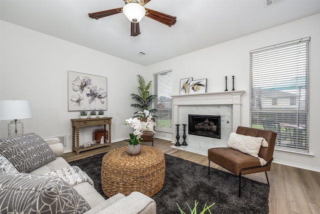 living room featuring hardwood / wood-style floors, a fireplace, and ceiling fan