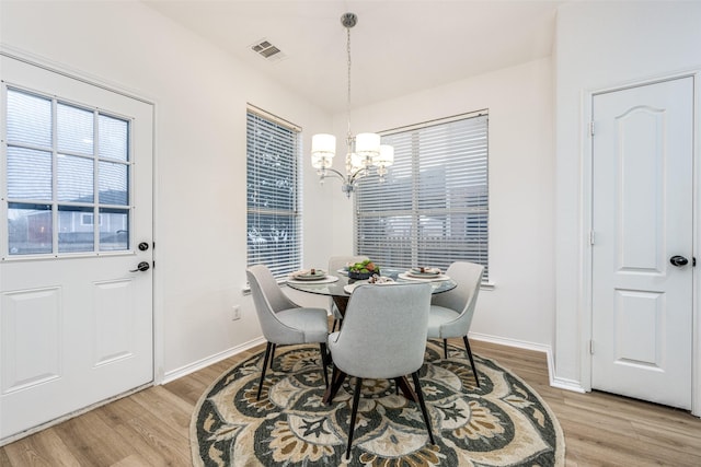 dining space featuring a chandelier and light wood-type flooring