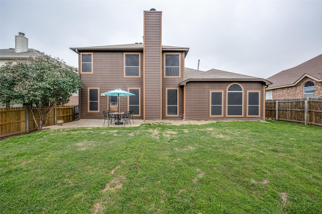 back of property with a patio area and a lawn