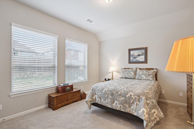 carpeted bedroom with lofted ceiling, visible vents, and baseboards