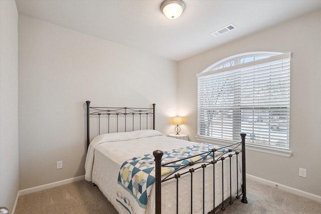 bedroom featuring multiple windows and light colored carpet