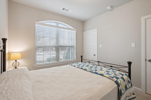 carpeted bedroom featuring visible vents