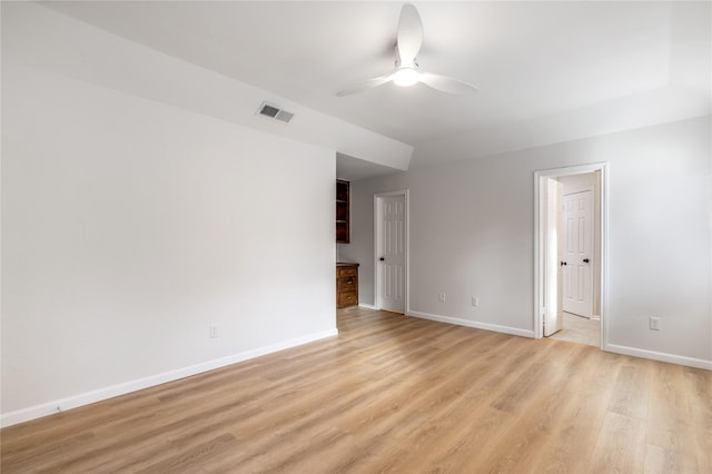 spare room featuring ceiling fan, visible vents, baseboards, and light wood-style flooring