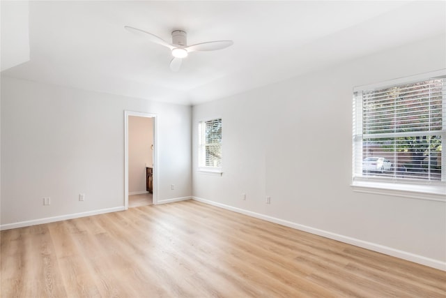 unfurnished room featuring ceiling fan, light wood-style flooring, and baseboards